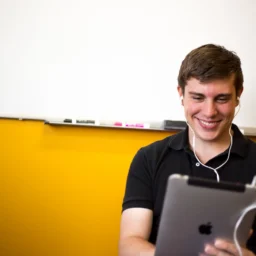 smiling student with headphone taking assessment.